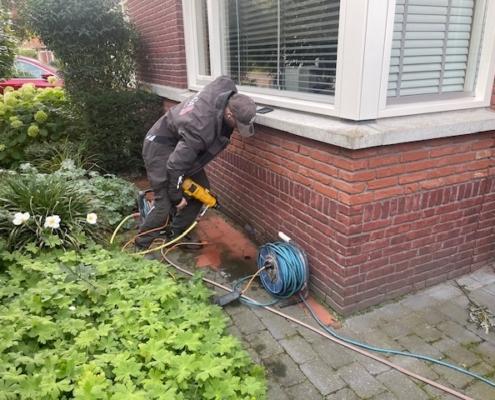 Ventilatiegaten boren in de kruipruimte.