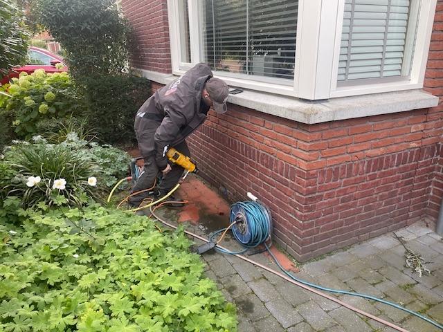 Ventilatiegaten boren in de kruipruimte.